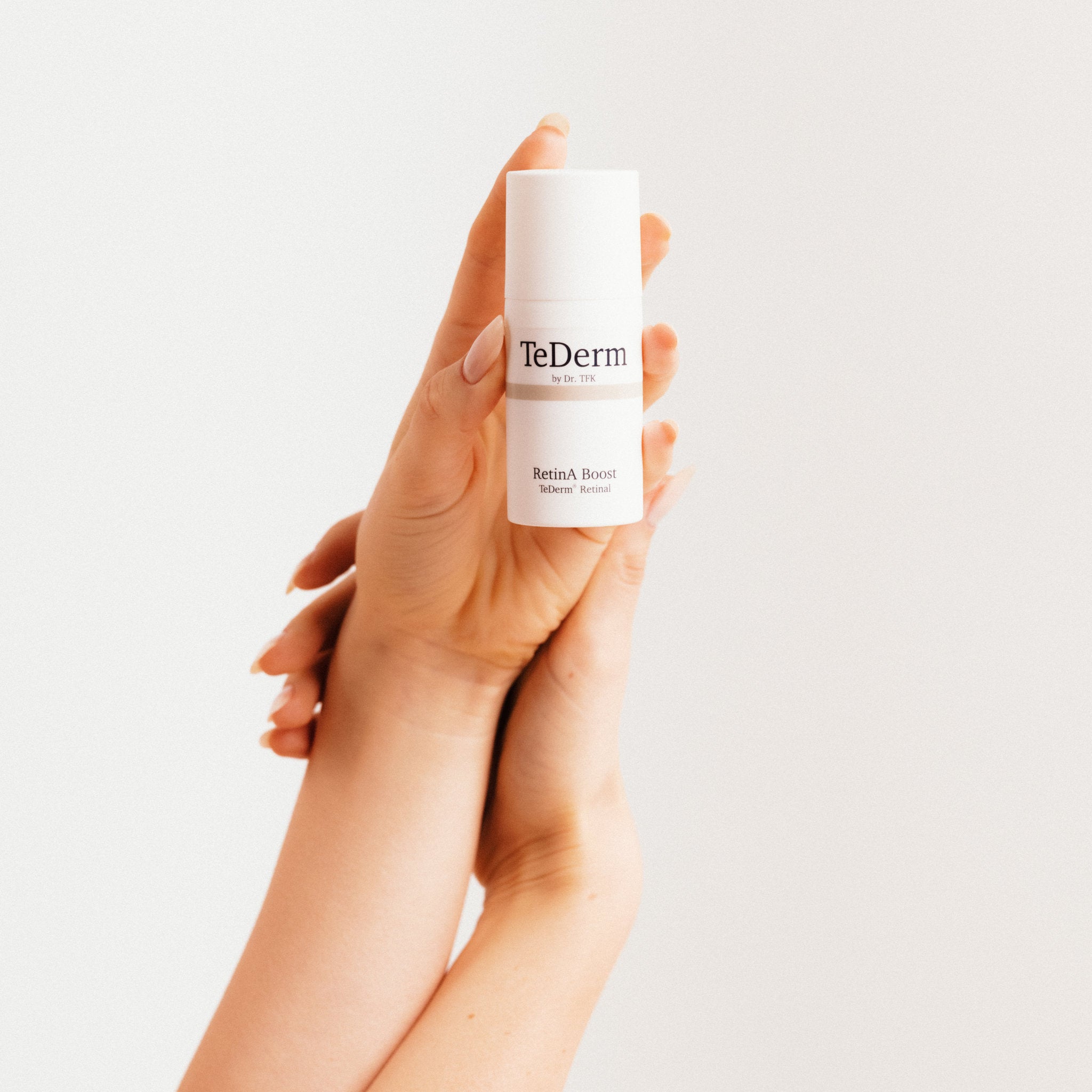 Hands holding TeDerm RetinA Boost serum – retinal night care